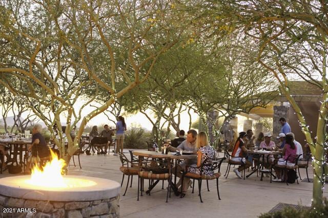 view of community featuring a patio area and a fire pit