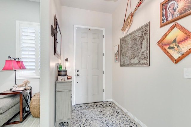 foyer entrance with a healthy amount of sunlight and baseboards