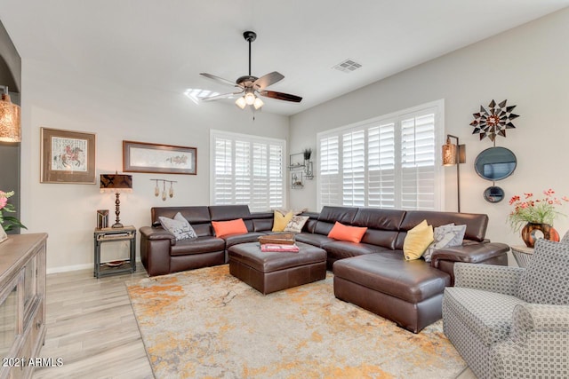 living room with light wood finished floors, baseboards, visible vents, and a ceiling fan