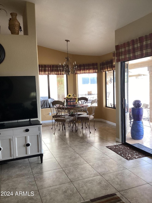 dining space featuring lofted ceiling, an inviting chandelier, and light tile patterned flooring