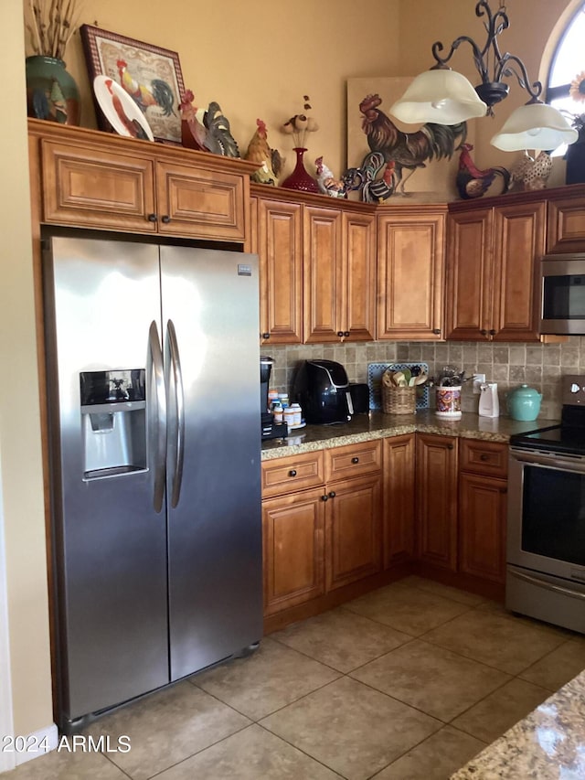 kitchen featuring backsplash, stainless steel appliances, light tile patterned flooring, and stone counters