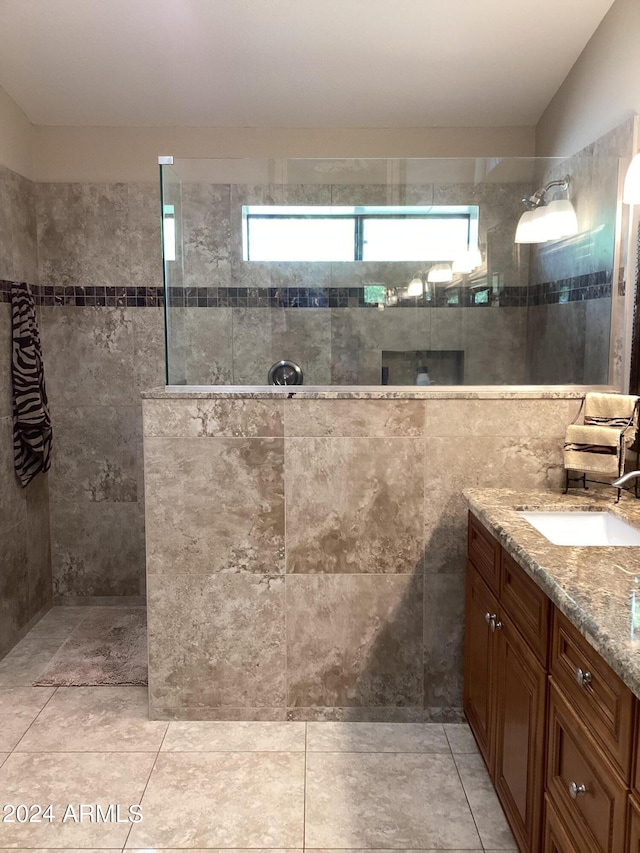 bathroom with tiled shower, tile walls, and vanity