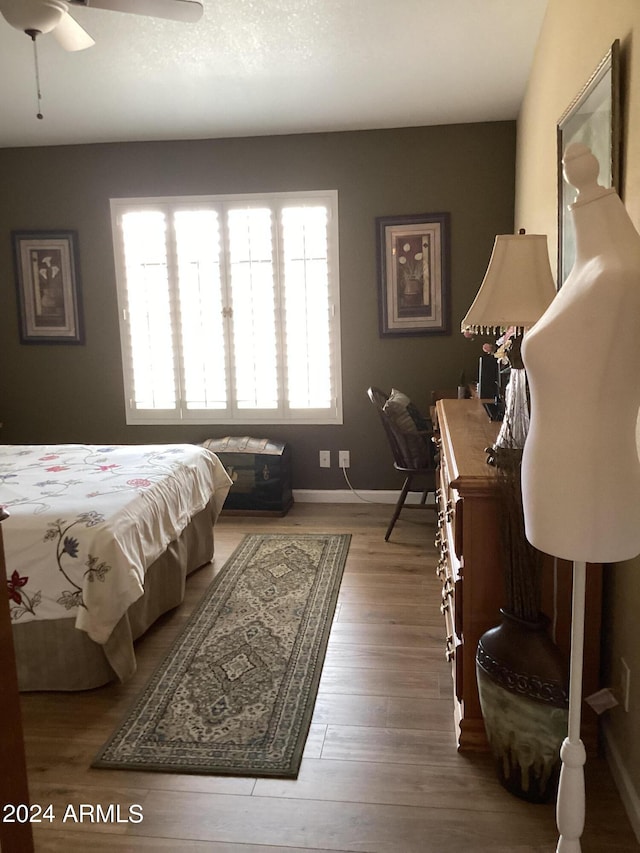 bedroom with ceiling fan and wood-type flooring