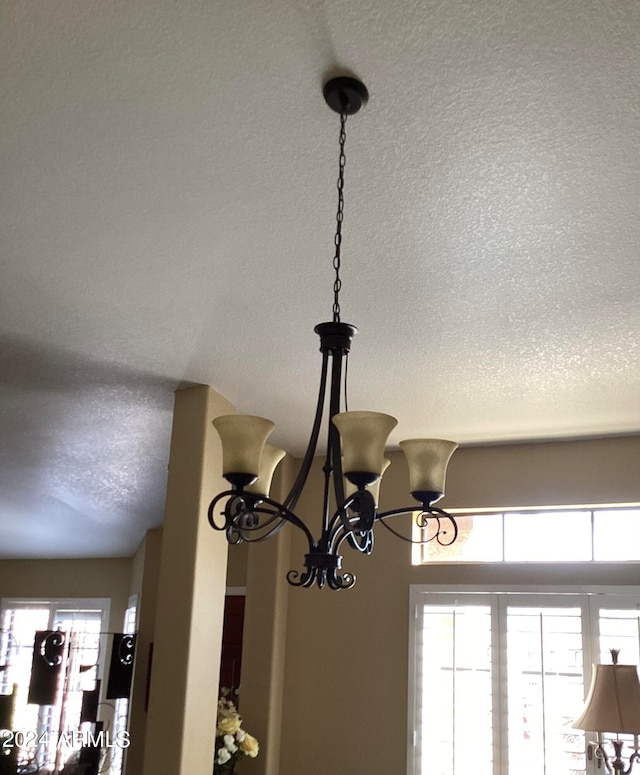 room details with a textured ceiling and a notable chandelier