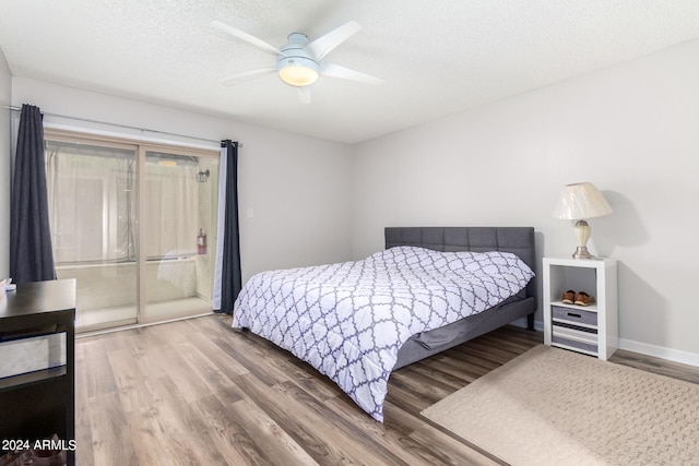 bedroom with ceiling fan, hardwood / wood-style flooring, and a textured ceiling