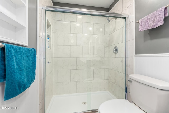 bathroom with toilet and an enclosed shower