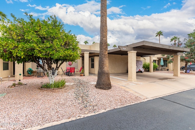 adobe home featuring a patio and a carport