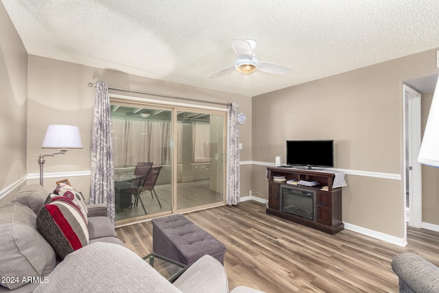 living room featuring hardwood / wood-style floors, a textured ceiling, and ceiling fan