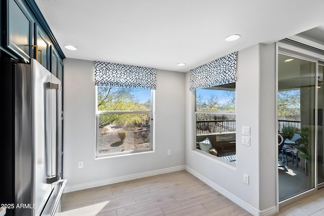 unfurnished dining area featuring a healthy amount of sunlight and light wood-type flooring