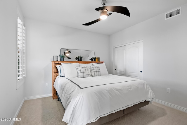 carpeted bedroom with ceiling fan and a closet