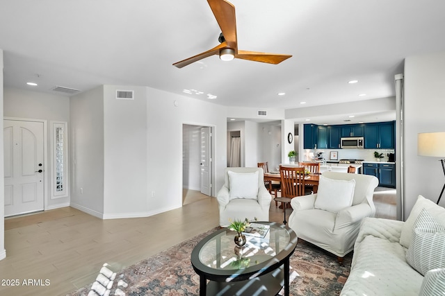 living room featuring light hardwood / wood-style flooring and ceiling fan