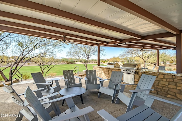 view of patio featuring ceiling fan, an outdoor kitchen, and a grill