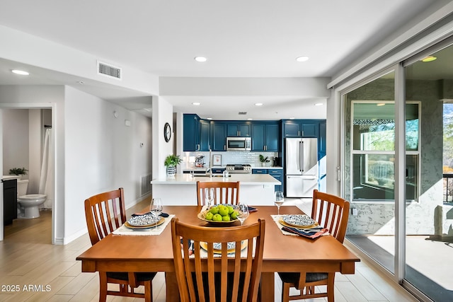 dining area with sink and light hardwood / wood-style floors