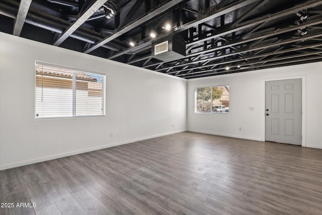 empty room featuring visible vents, baseboards, and wood finished floors