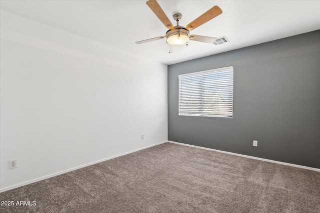 carpeted spare room with visible vents, ceiling fan, and baseboards