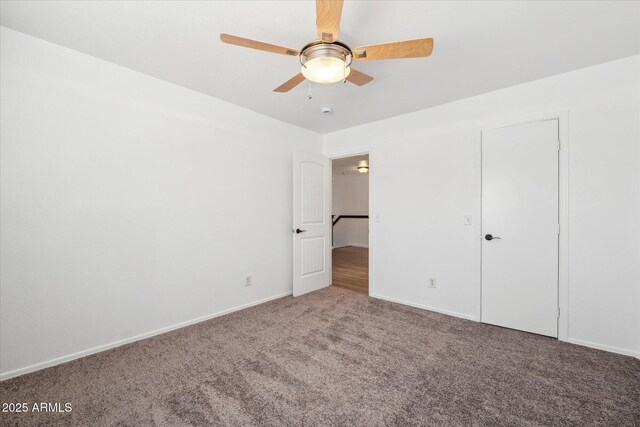 unfurnished bedroom with baseboards, a ceiling fan, and carpet