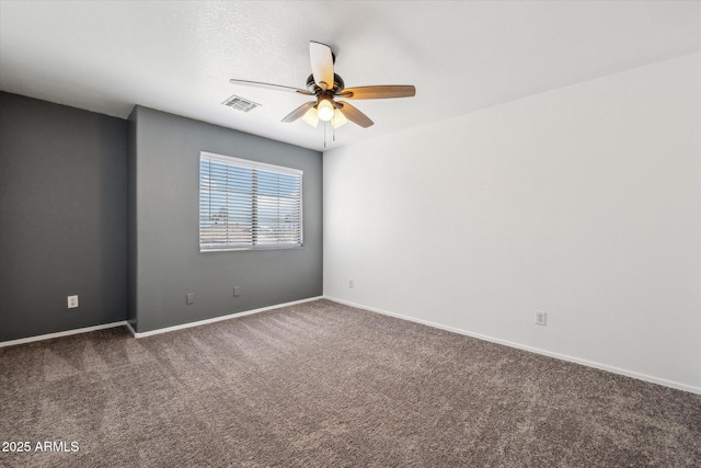 empty room with carpet, visible vents, baseboards, and ceiling fan
