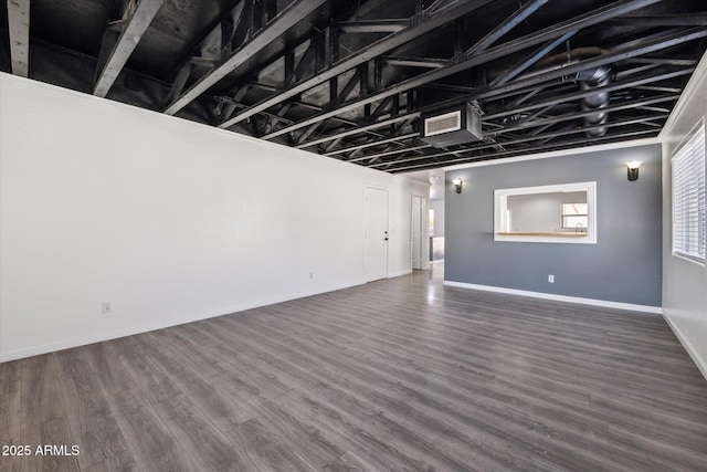 unfurnished living room with visible vents, baseboards, and wood finished floors
