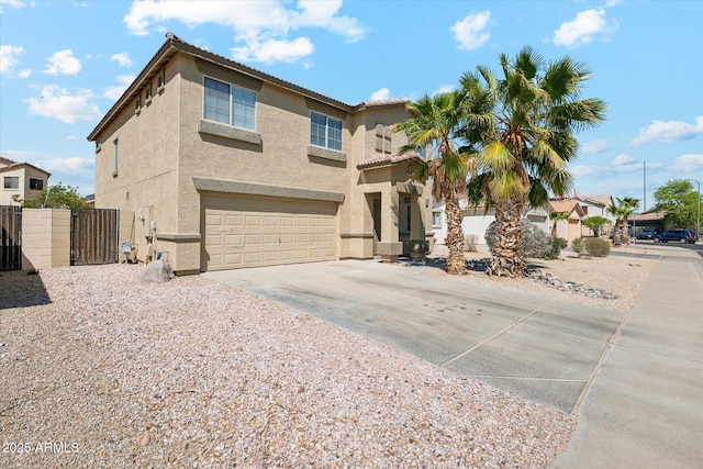 view of front of property with a tiled roof, a garage, stucco siding, a gate, and concrete driveway