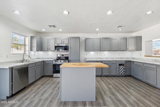 kitchen featuring gray cabinetry, visible vents, a sink, and appliances with stainless steel finishes
