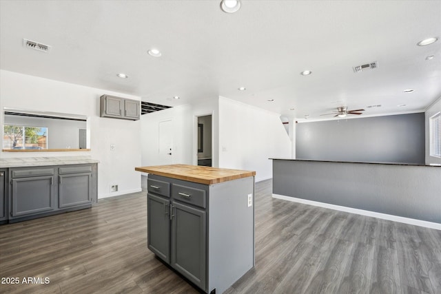 kitchen featuring butcher block countertops, visible vents, baseboards, and gray cabinets