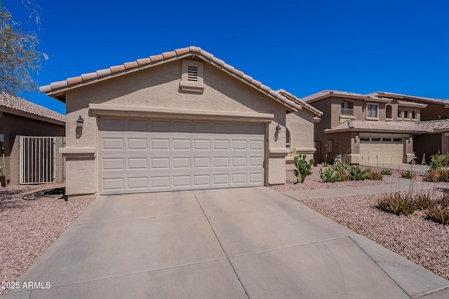 2714 E Valencia Dr, Phoenix, AZ 85042 - view of front of home with stucco siding, concrete driveway, an attached garage, and a tile roof