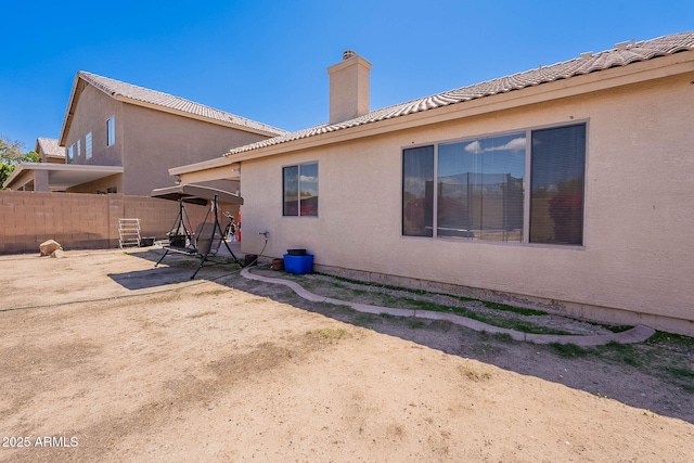 2714 E Valencia Dr, Phoenix, AZ 85042 - rear view of property featuring fence, a chimney, a patio area, and stucco siding
