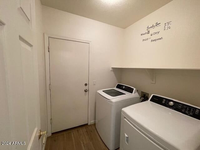 laundry area with a textured ceiling, dark hardwood / wood-style floors, and separate washer and dryer