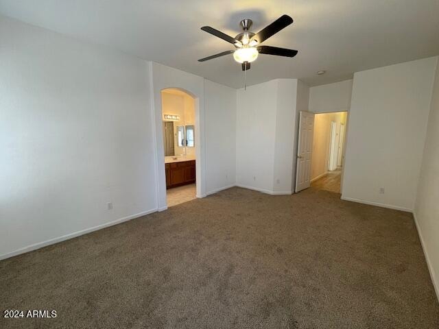 unfurnished bedroom featuring connected bathroom, carpet, and ceiling fan