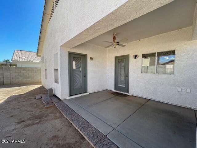 view of exterior entry featuring a patio area and ceiling fan