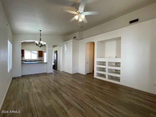 unfurnished living room featuring lofted ceiling, ceiling fan with notable chandelier, and dark hardwood / wood-style flooring