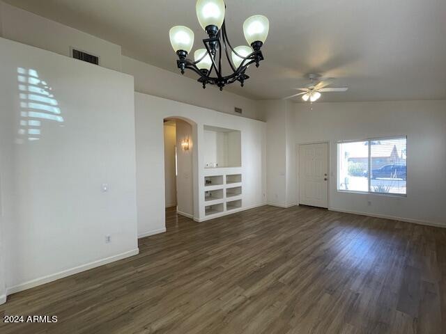 unfurnished living room featuring lofted ceiling, dark hardwood / wood-style flooring, and ceiling fan with notable chandelier