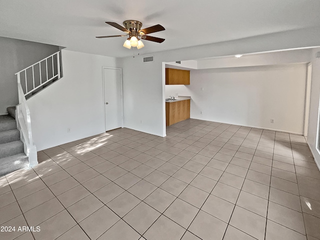 unfurnished living room featuring ceiling fan and light tile patterned floors