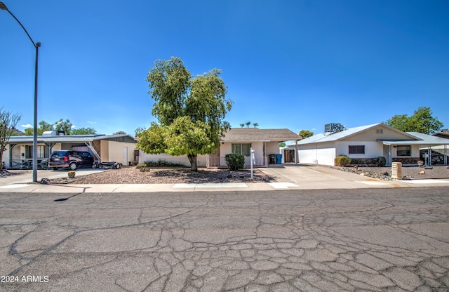 single story home with an attached carport, concrete driveway, cooling unit, and stucco siding