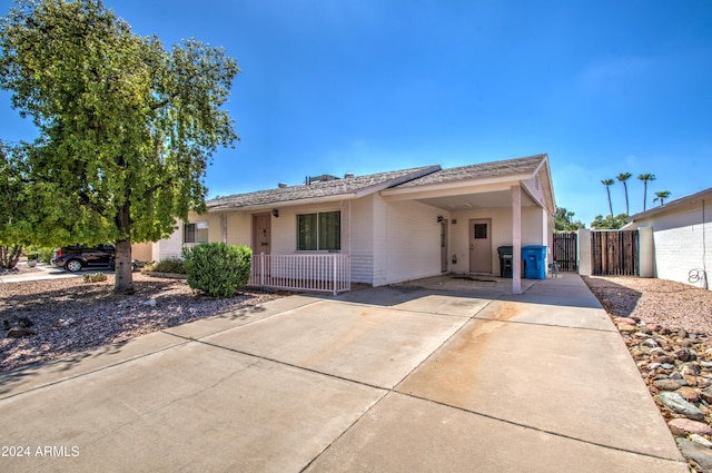 ranch-style house with fence, a carport, and brick siding