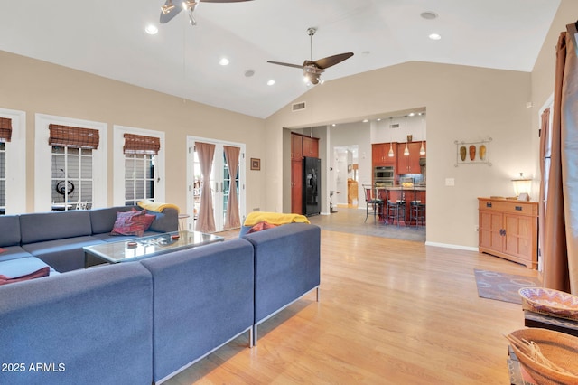 living room with high vaulted ceiling, ceiling fan, and light wood-type flooring