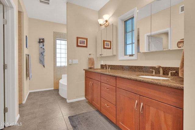 bathroom with tile patterned floors, a bathtub, and vanity