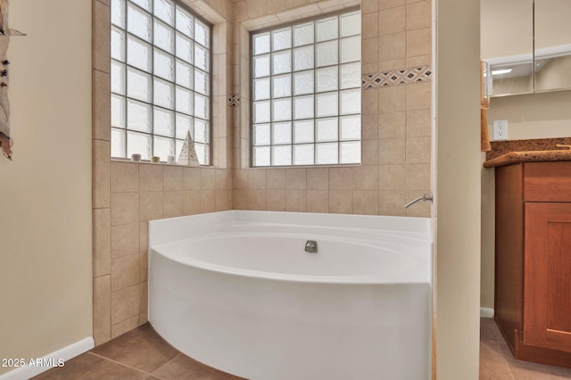 bathroom featuring vanity, tile patterned flooring, and a tub