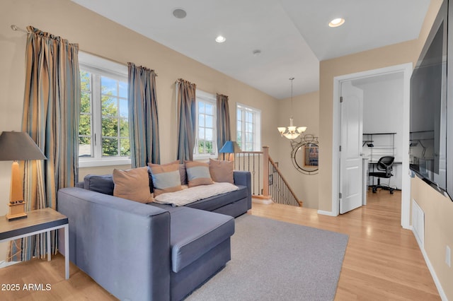 living room featuring light wood-type flooring and an inviting chandelier