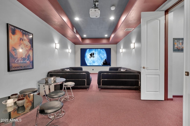 cinema with a tray ceiling and carpet flooring