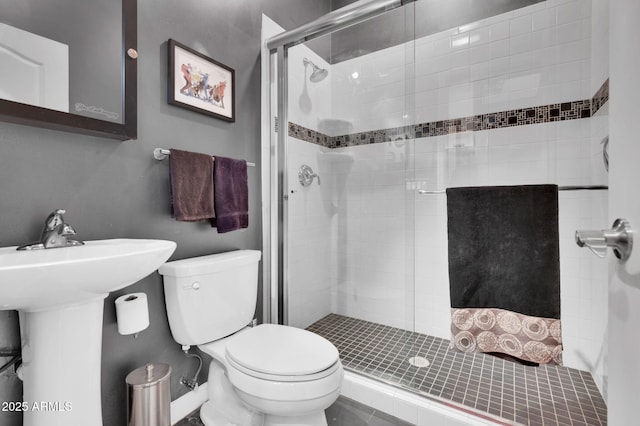 bathroom with a shower with door and toilet