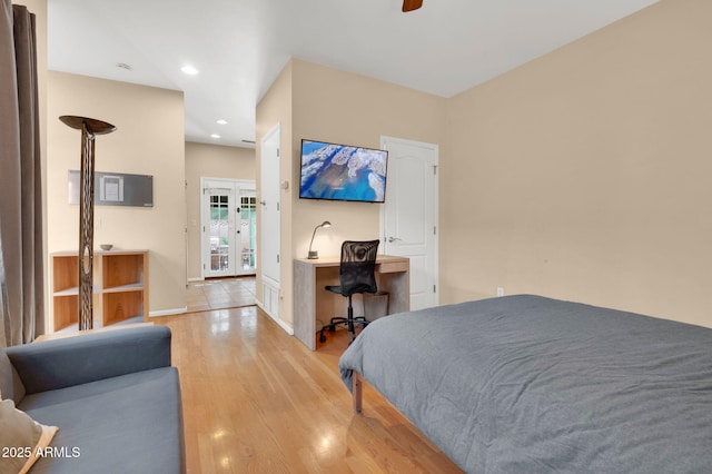 bedroom with built in desk, light hardwood / wood-style flooring, french doors, and ceiling fan