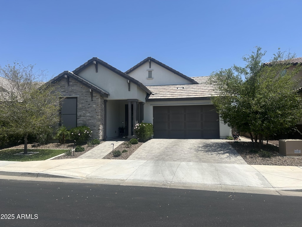 26943 N 74th Ave, Peoria, AZ 85383 - view of front of home with driveway, an attached garage, stucco siding, and stone siding