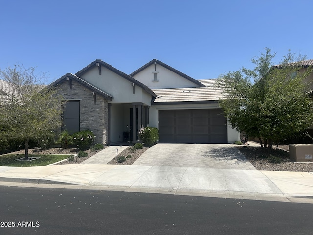 26943 N 74th Ave, Peoria, AZ 85383 - view of front of home with driveway, an attached garage, stucco siding, and stone siding