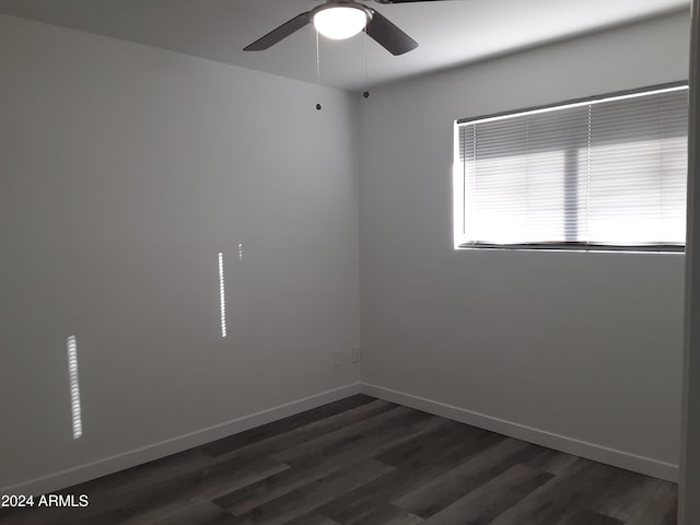 empty room with dark hardwood / wood-style floors and ceiling fan