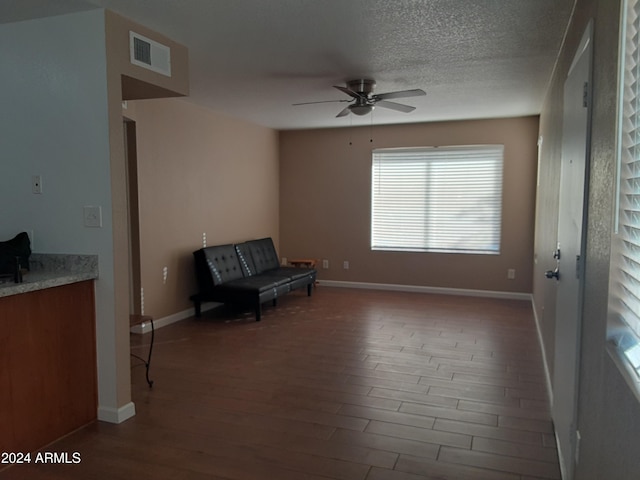 unfurnished room featuring ceiling fan, hardwood / wood-style flooring, and a textured ceiling