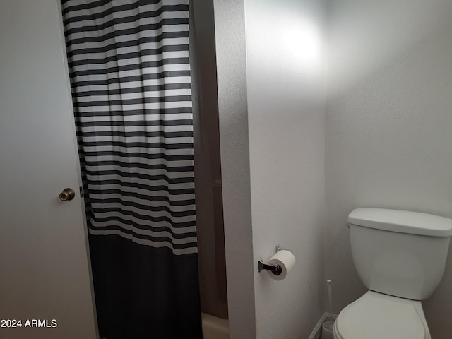 bathroom featuring toilet and a shower with shower curtain