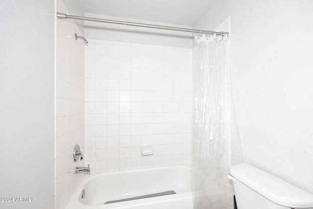 bathroom featuring shower / bath combination with curtain and toilet