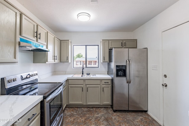 kitchen featuring gray cabinetry, sink, light stone countertops, a textured ceiling, and stainless steel appliances