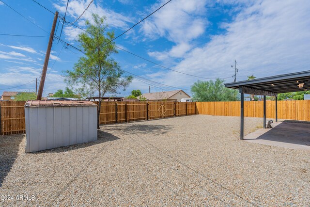 view of yard featuring a storage unit and a patio area